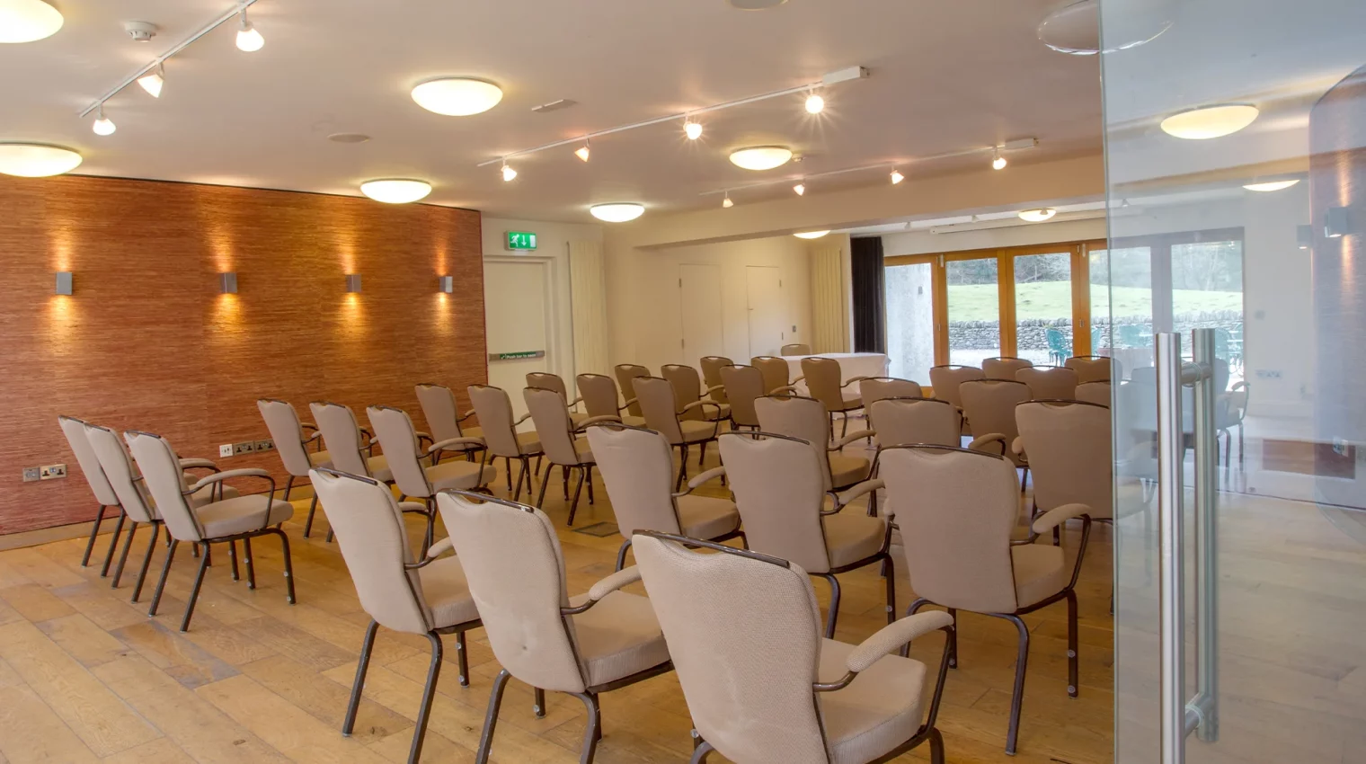 Modern main conference space with wood floor, laid out in rows of chairs for a corporate event