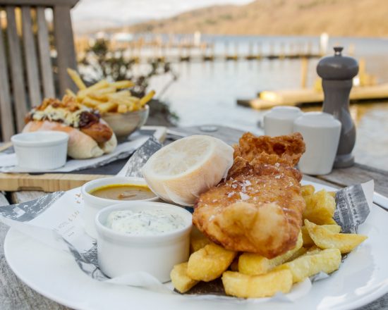 Two plates of fish and chips on an outside table by Lake Windermere