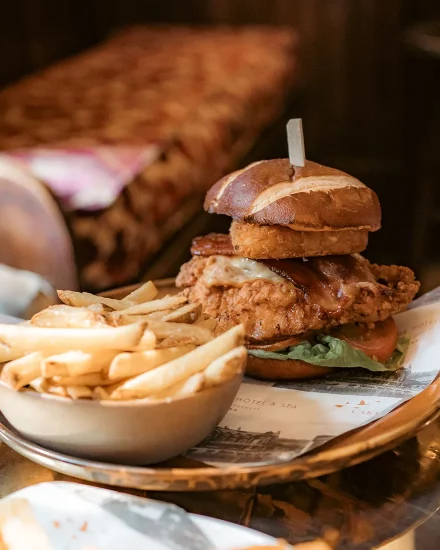 A succulent chicken burger with chips, presented in a rustic style