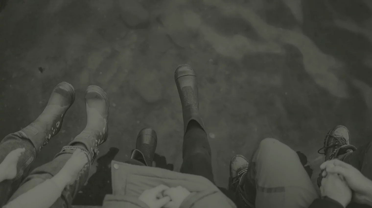 two tone background image of feet in boots off a jetty