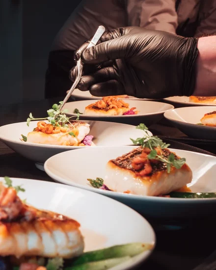 A careful hand finishes the meal professionally