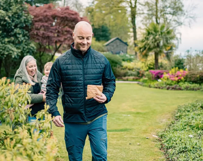 A family walk through gardens to feed ducks