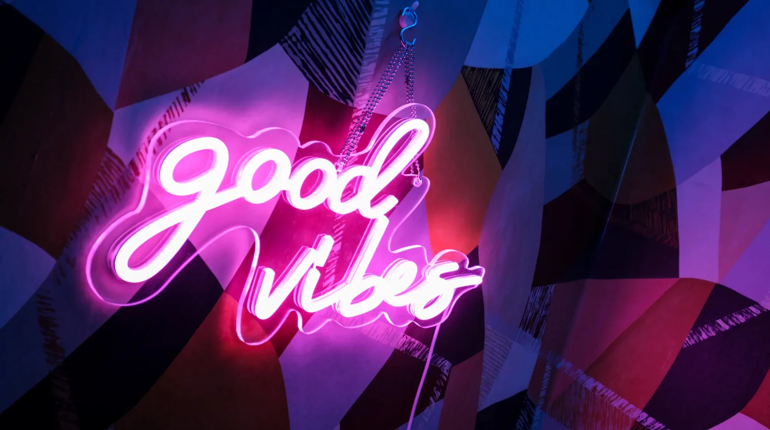 Neon wall sign that says 'Good Vibes' glowing pink