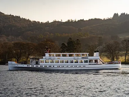 Windermere ferry on lake with fells behind