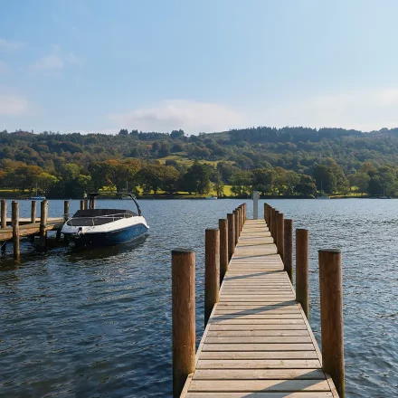 Private jetty onto Lake Windermere with boat moored