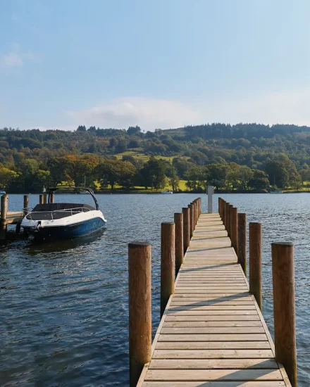 Private jetty onto Lake Windermere with boat moored