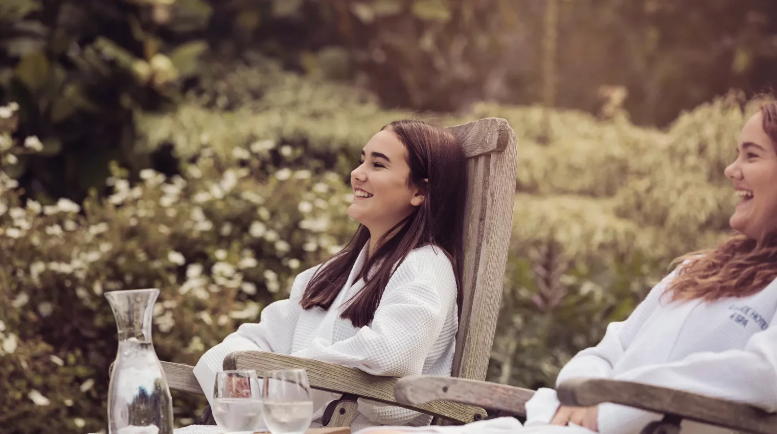Two girls in gowns on loungers in the spa garden