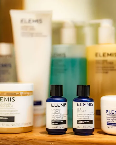 Spa treatment products in green, blue and white bottles by Elemis