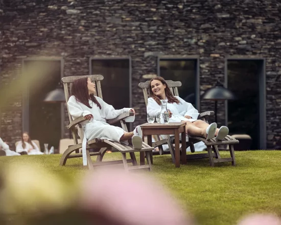 Two girls in gowns on loungers in the spa garden