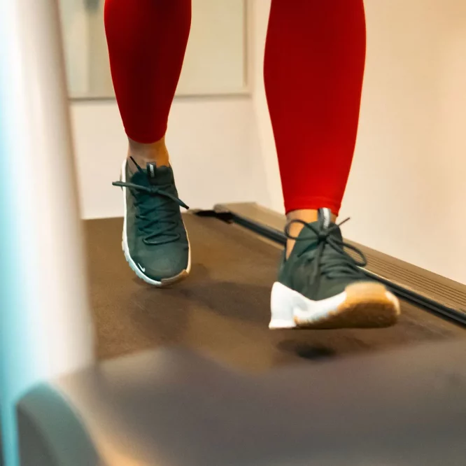 close up of runner on running machine with running shoes