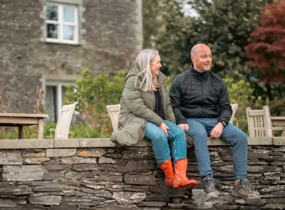 Couple sat on a wall relaxing in the hotel garden