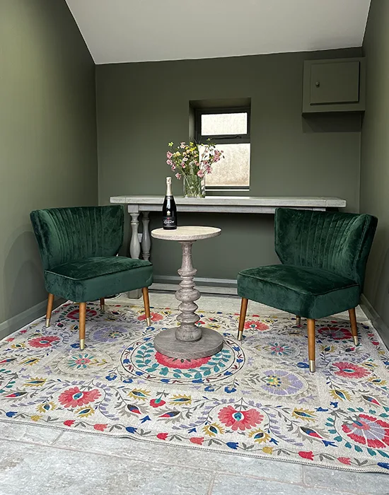 A small space with modern floral decor and two chairs and a table