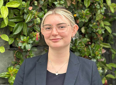 Head and shoulders of Lakeside Hotel team member with leafy background