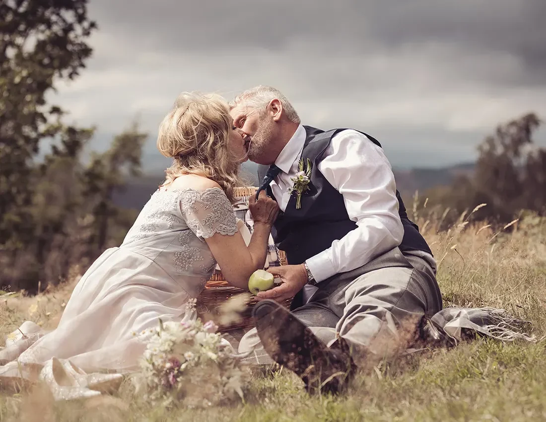 Newly married couple enjoy a picnic on the hillside near the hotel