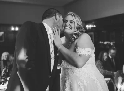 Happy couple embracing on dance floor at their evening reception at the Lakeside