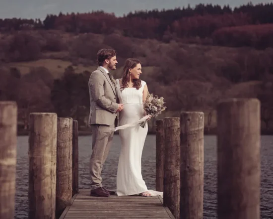 Newlyweds enjoy the view from the end of the jetty overlooking Lake Windermere