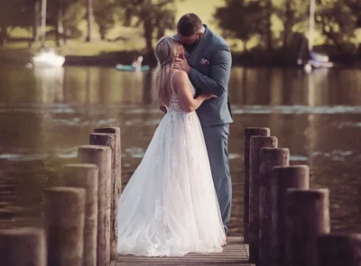 Newlyweds enjoy the view and a kiss, at the end of the jetty overlooking Lake Windermere