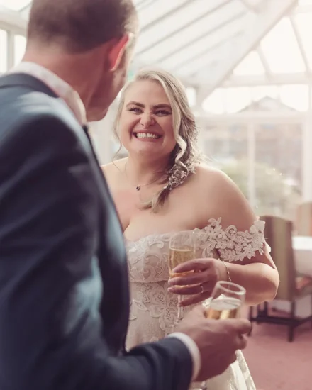 Happy couple celebrate in the conservatory with a glass of bubbly