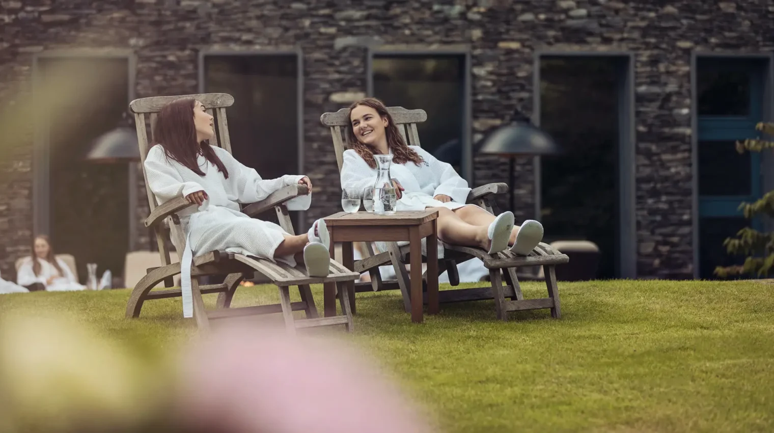 Two girls in gowns on loungers in the spa garden